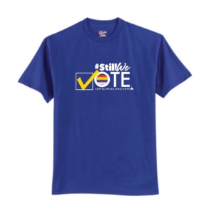 Still We Vote short sleeved t-shirt in royal blue. #StillWe on top of the word Vote. The V is a canary yellow checkmark followed by the O with the inclusive Pride colors inside of it. Followed the the remaining block letters T and E. At the bottom is provides the url CapitalPride.org/Vote.